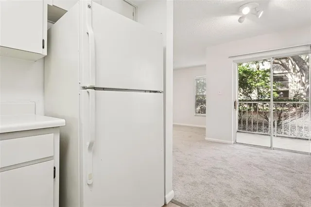 a view of a hallway with wooden cabinets