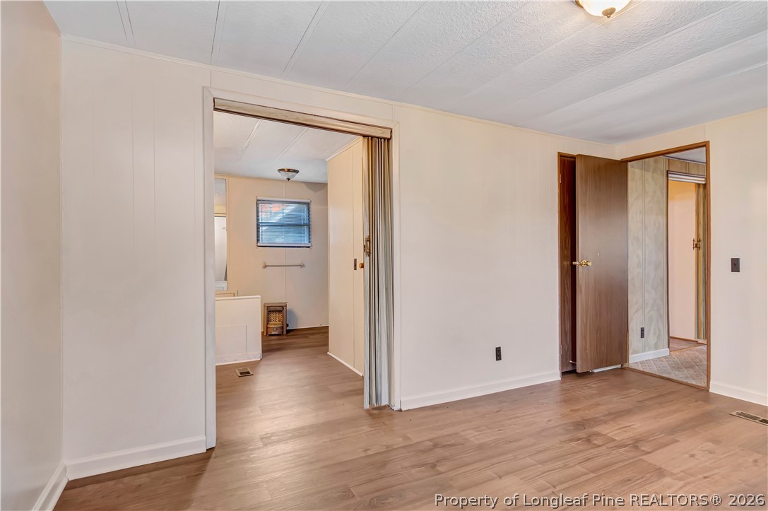 727 Rice Road Lumberton, NC 28358 - Photo 15 of 30 a view of a hallway with wooden floor and a bathroom