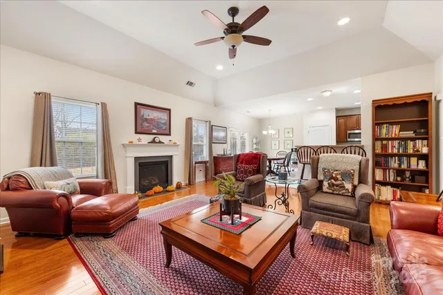 a living room with furniture a fireplace and a chandelier