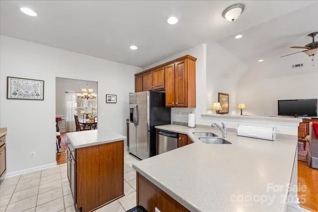 a kitchen with stainless steel appliances a stove refrigerator sink and wooden floor