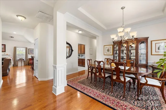 a view of a dining room and livingroom with furniture wooden floor a chandelier