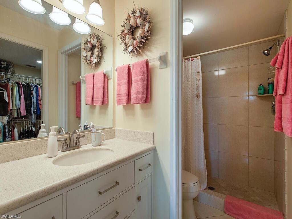 5932 Cranbrook Way, Unit C106 Naples, FL 34112 - Photo 11 of 13 Full bath featuring vanity, toilet, a tile shower, a walk in closet, and tile patterned flooring