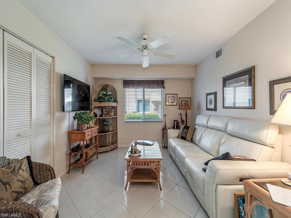 5932 Cranbrook Way, Unit C106 Naples, FL 34112 - Photo 5 of 13 Living room featuring ceiling fan, light tile patterned floors, and baseboards
