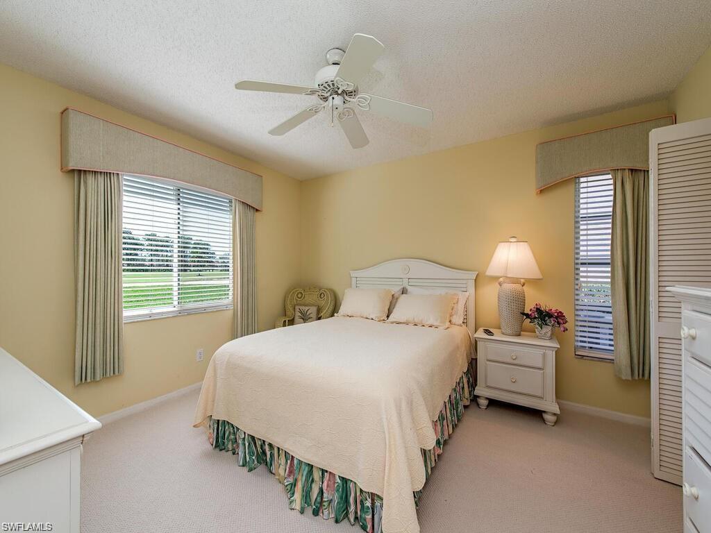 5932 Cranbrook Way, Unit C106 Naples, FL 34112 - Photo 6 of 13 Bedroom featuring light carpet, baseboards, a ceiling fan, and a textured ceiling