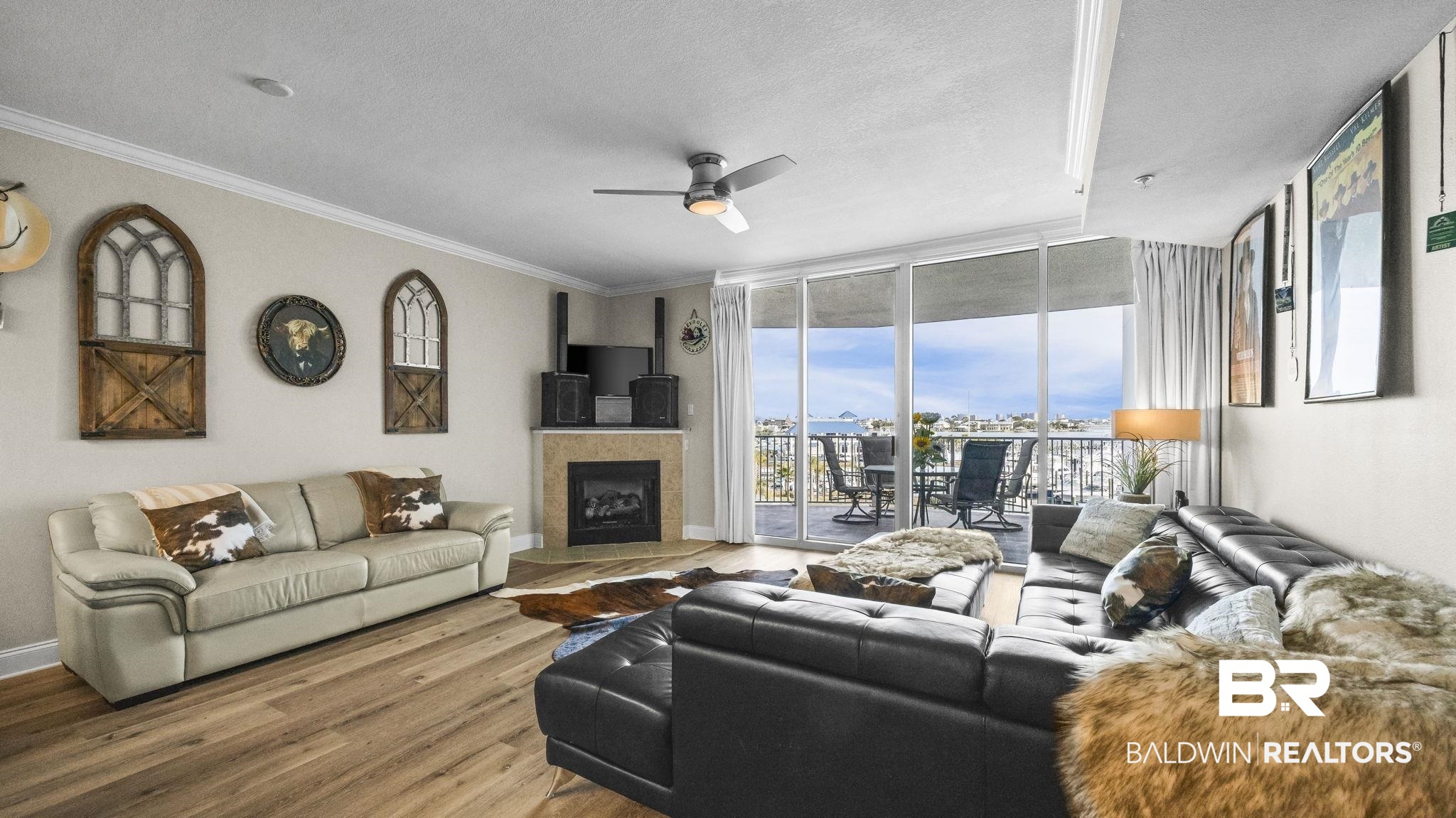 27800 Canal Road, Unit 313 Orange Beach, AL 36561 - Photo 2 of 23 Living room featuring floor to ceiling windows, a textured ceiling, wood finished floors, a ceiling fan, and a tile fireplace