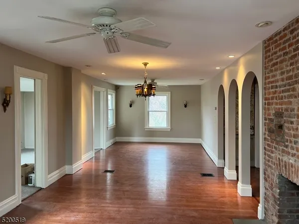 a view of a hallway with wooden floor and a ceiling fan