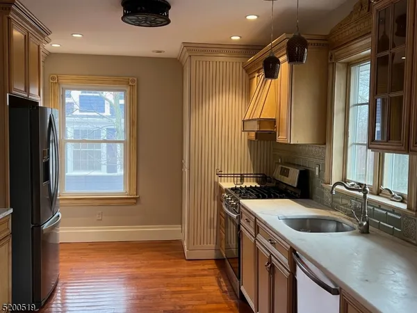 a kitchen that has a sink a stove and a refrigerator