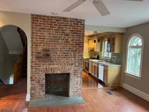 a living room with a fireplace windows and a wooden floor
