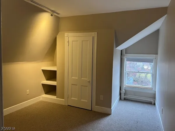 a view of an empty room with a fireplace and a window