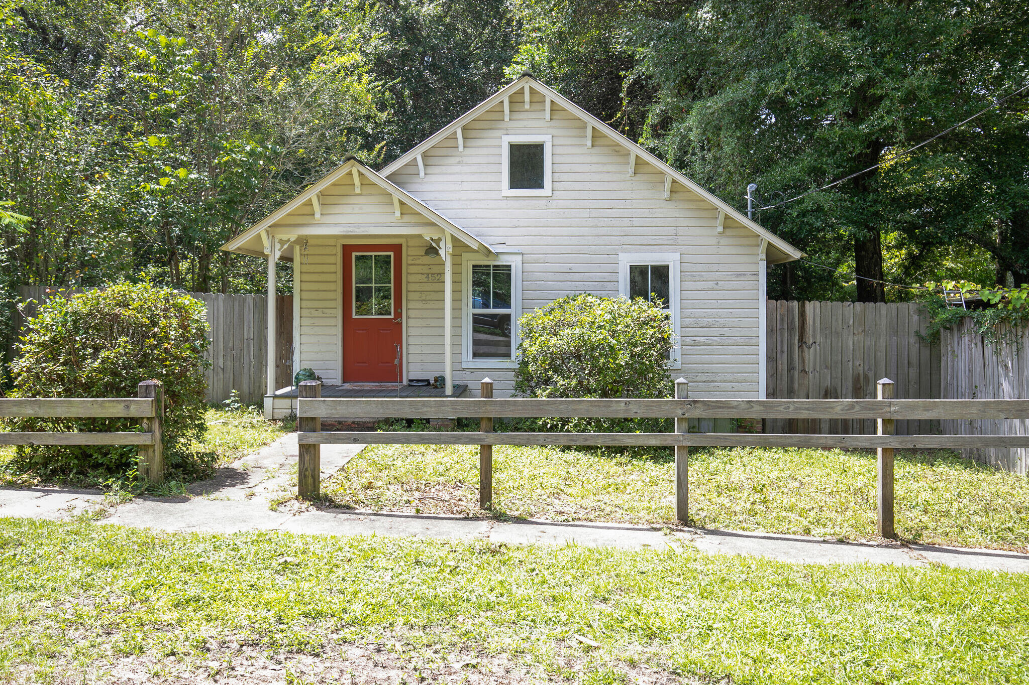 a view of a house with a yard chairs and a large tree