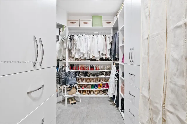 a spacious bedroom with a bed a dresser and a flat screen tv