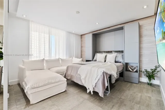 a bedroom with bed and a potted plant