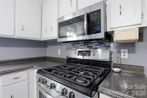 a kitchen with stainless steel appliances granite countertop a stove and a microwave