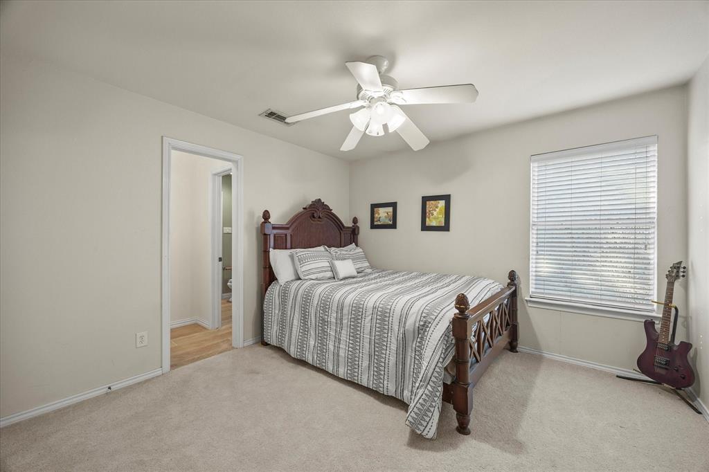 14633 Lakecrest Drive Addison, TX 75001 - Photo 11 of 14 a bedroom with a bed and a chandelier