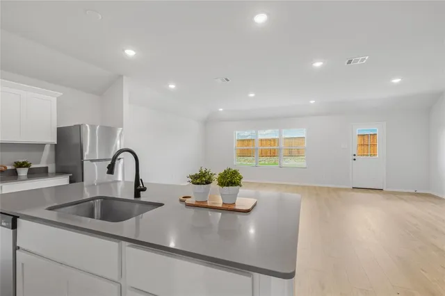 a kitchen with kitchen island a sink appliances and a counter top space