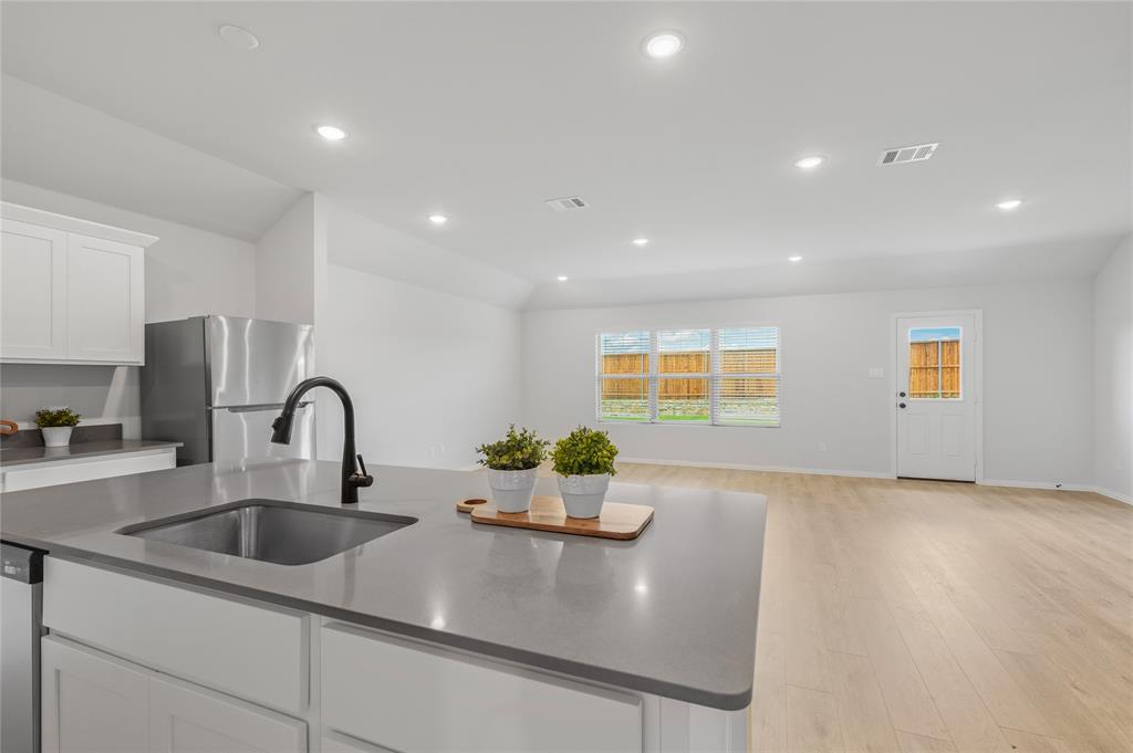 610 Ridgewood Drive Van Alstyne, TX 75495 - Photo 13 of 34 a kitchen with kitchen island a sink appliances and a counter top space
