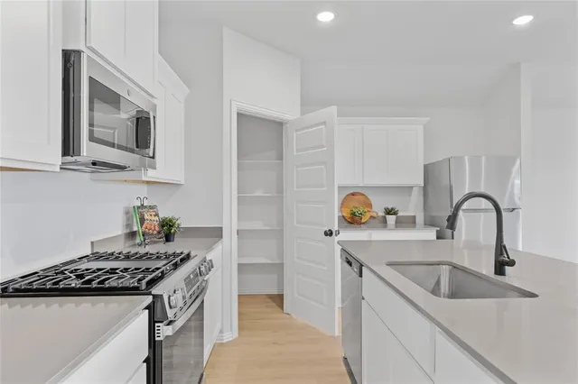 a kitchen with stainless steel appliances granite countertop a sink and a stove top oven