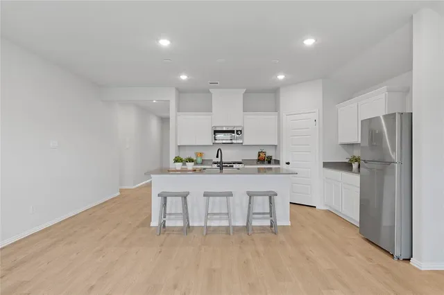 a kitchen with stainless steel appliances a refrigerator sink and microwave