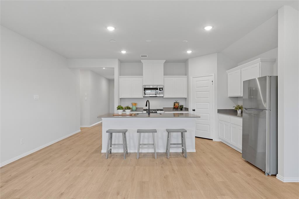 610 Ridgewood Drive Van Alstyne, TX 75495 - Photo 18 of 34 a kitchen with stainless steel appliances a refrigerator sink and microwave