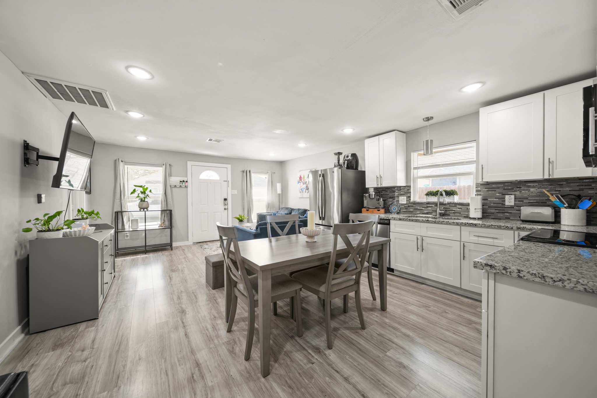 5605 Colfax Street Houston, TX 77020 - Photo 6 of 21 a kitchen with a dining table chairs wooden floor appliances and cabinets
