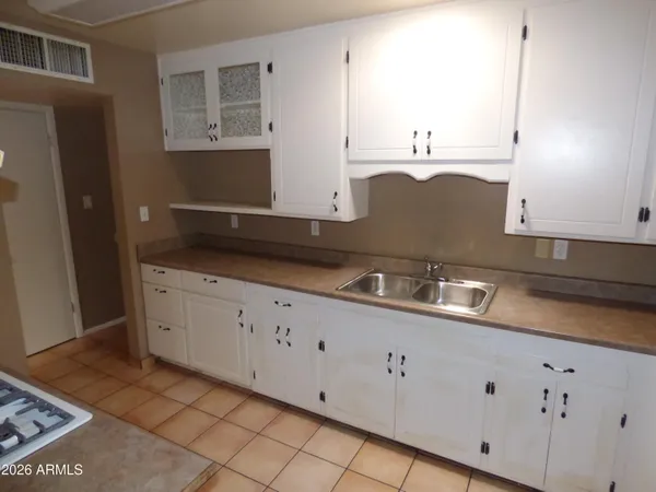 a kitchen with granite countertop white cabinets and stainless steel appliances