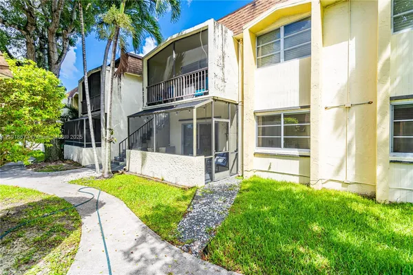 a view of a house with a yard and pathway