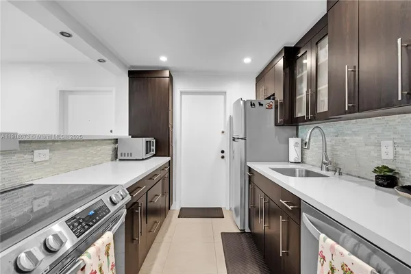 a kitchen with stainless steel appliances granite countertop a sink stove and refrigerator