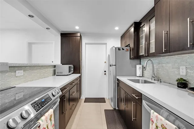 a kitchen with stainless steel appliances granite countertop a sink stove and refrigerator