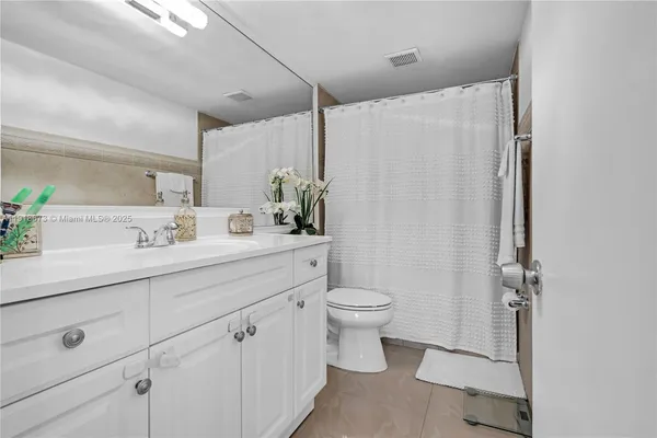 a bathroom with a sink toilet a mirror and shower
