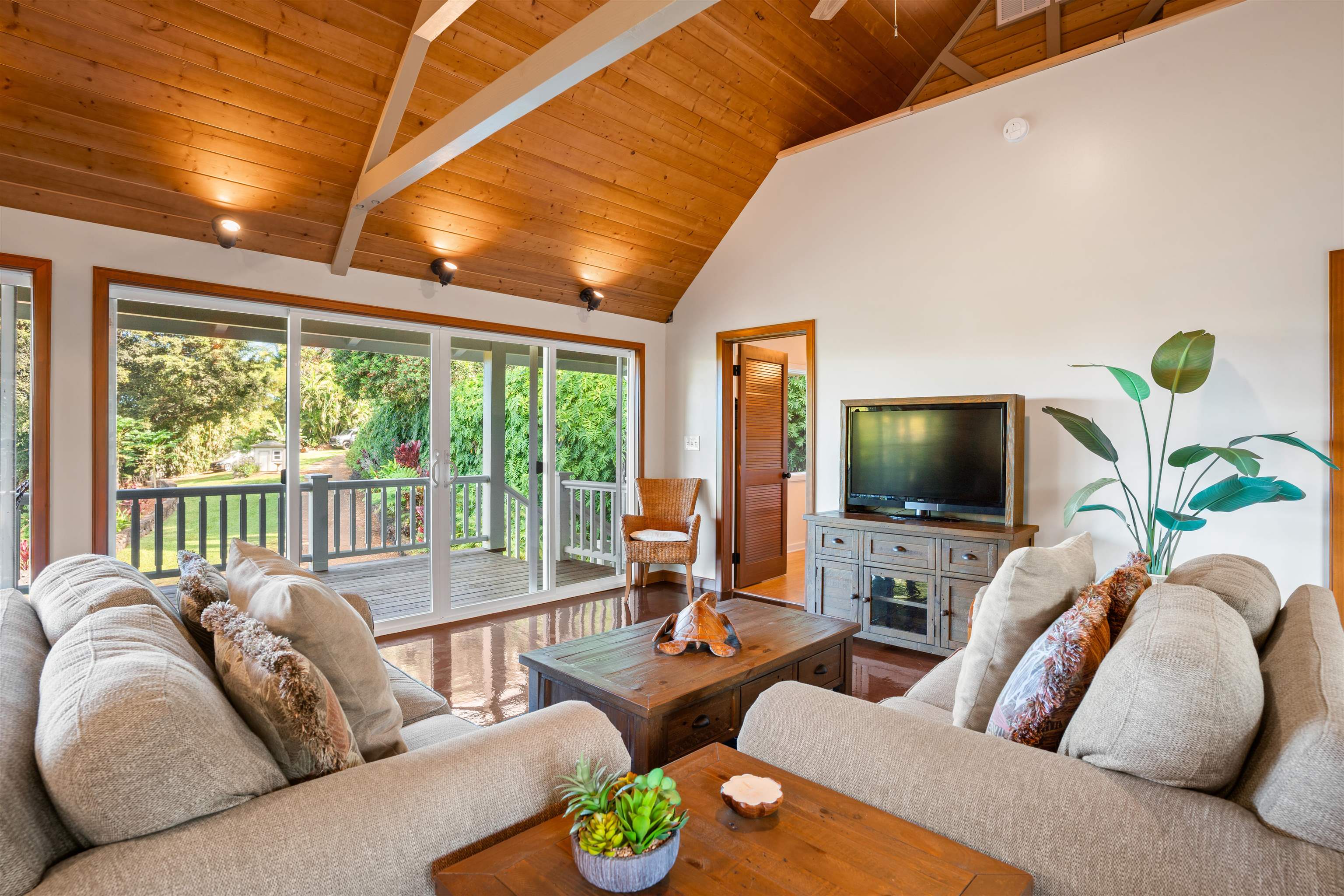 655 Kulike Road, Unit B Haiku, HI 96708 - Photo 11 of 38 a living room with furniture a flat screen tv and a large window
