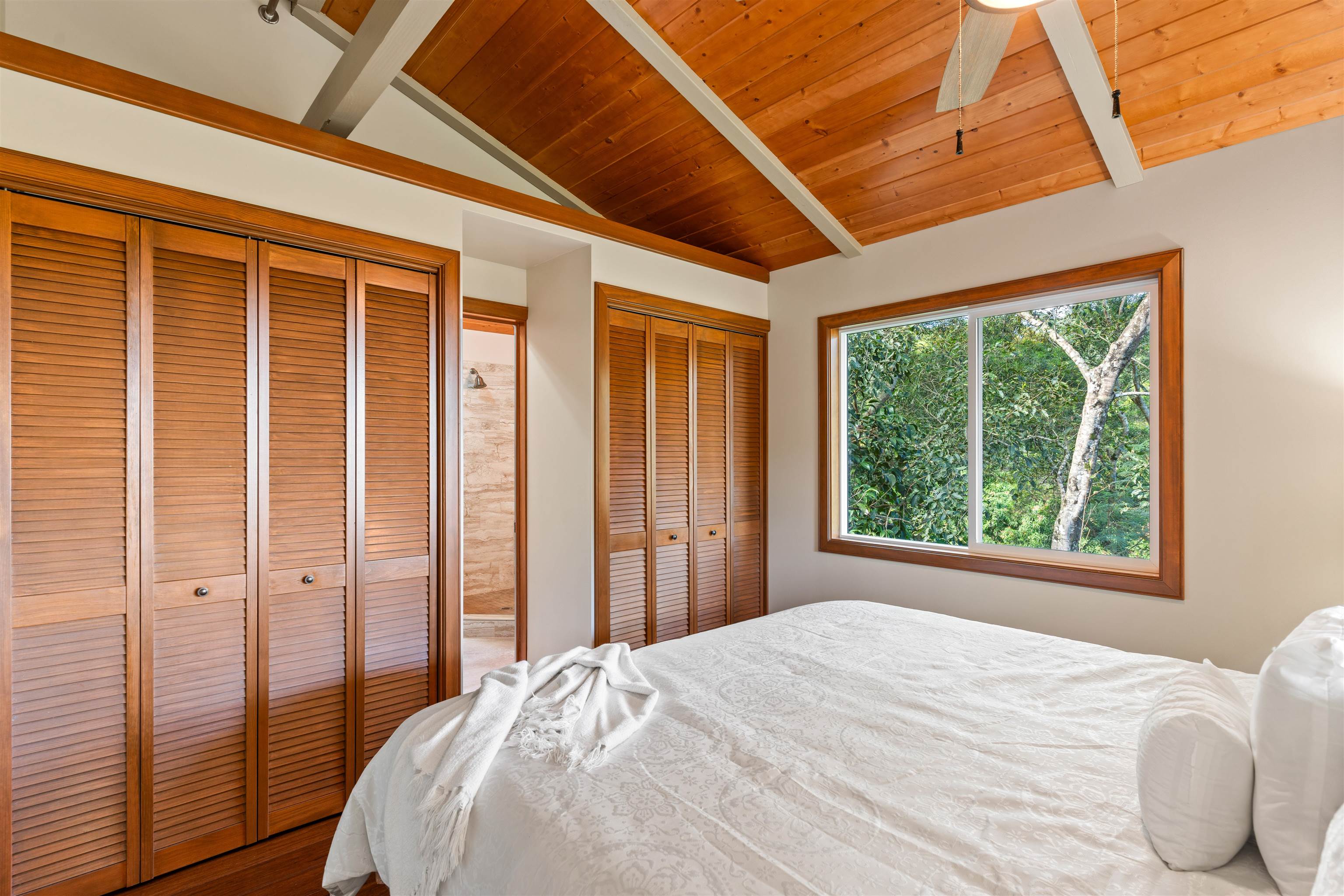 655 Kulike Road, Unit B Haiku, HI 96708 - Photo 22 of 38 a bedroom with a bed and a large window