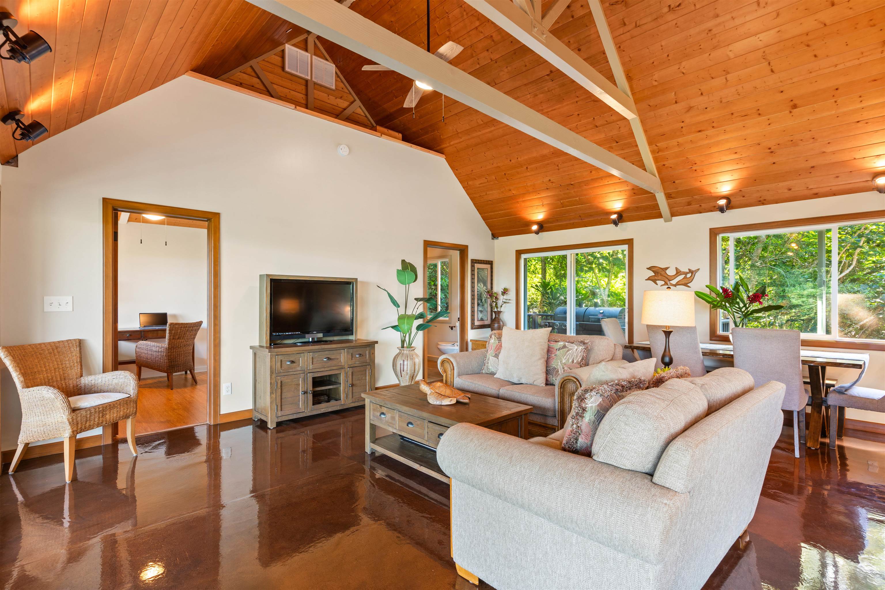 655 Kulike Road, Unit B Haiku, HI 96708 - Photo 10 of 38 a living room with furniture a flat screen tv and a floor to ceiling window