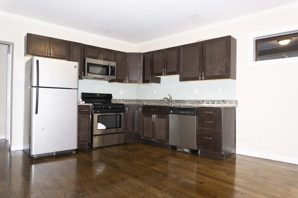 75 Elm Street Watertown, MA 02472 - Photo 6 of 12 a kitchen with granite countertop a refrigerator and a stove