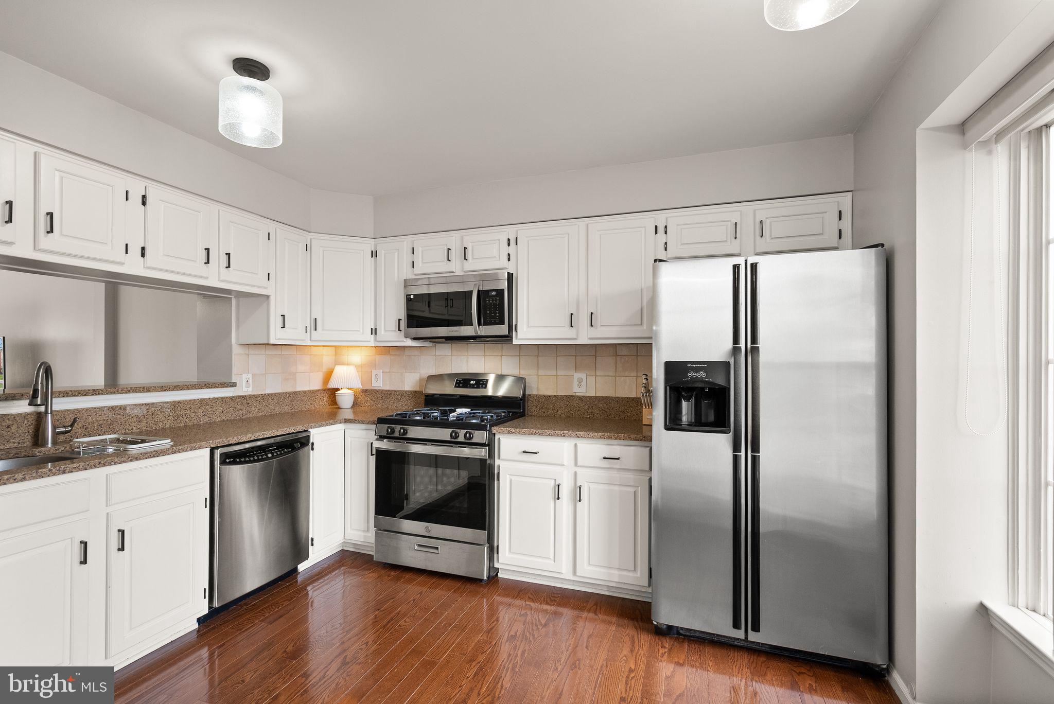 6020 Kestner Circle Alexandria, VA 22315 - Photo 7 of 59 a kitchen with cabinets stainless steel appliances a sink and wooden floor