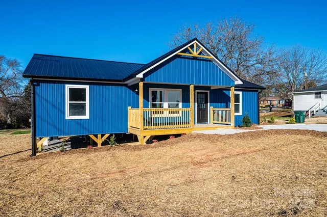 a open kitchen with stainless steel appliances granite countertop a stove a refrigerator a kitchen island a sink dishwasher a dining table and chairs with wooden floor