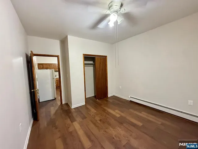 an empty room with closet and a chandelier fan