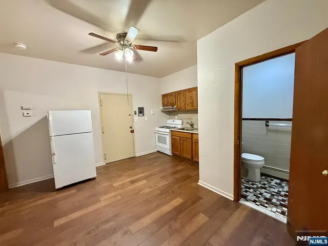 a view of a kitchen with a sink and dishwasher a refrigerator with wooden floor
