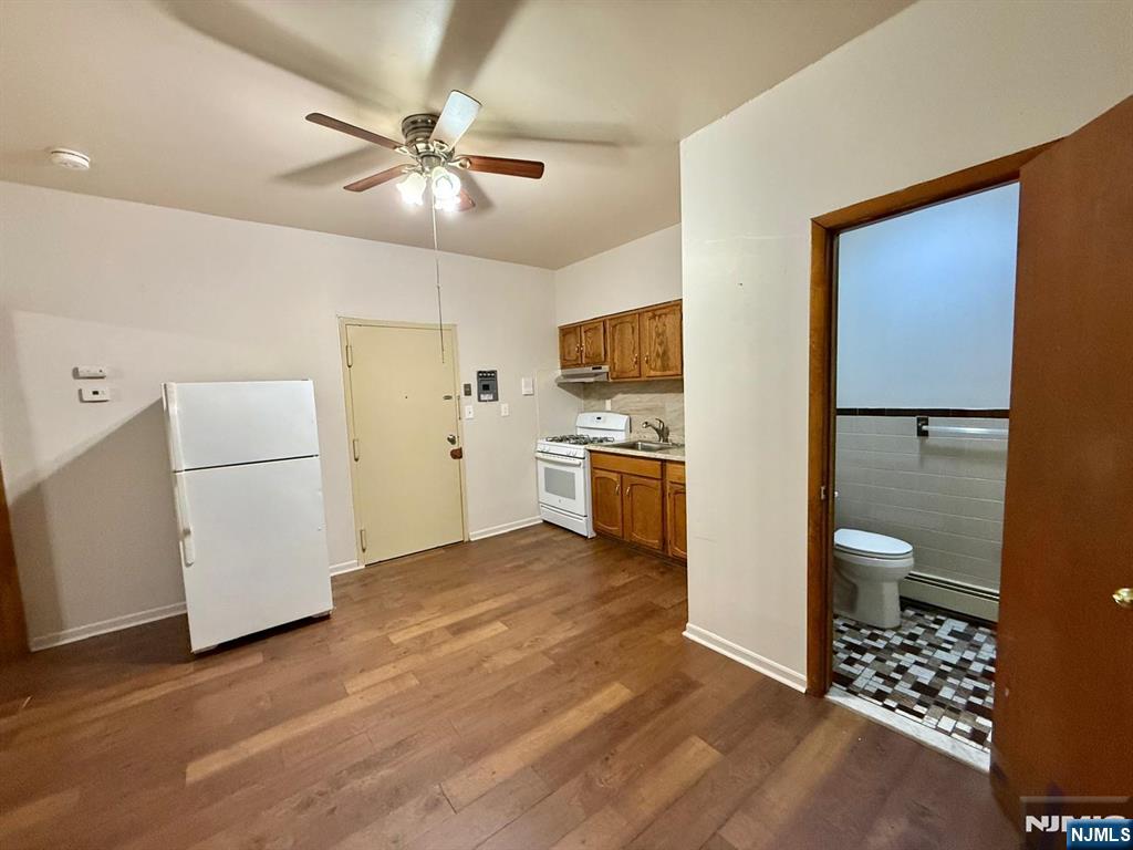 239-243 Harrison Avenue, Unit 10 Harrison, NJ 07029 - Photo 5 of 6 a view of a kitchen with a sink and dishwasher a refrigerator with wooden floor