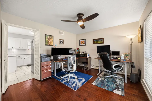 a view of a workspace with wooden floor and a window