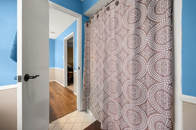 a bathroom with a bathtub and shower curtain