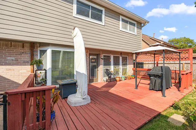a view of a house with wooden deck and furniture