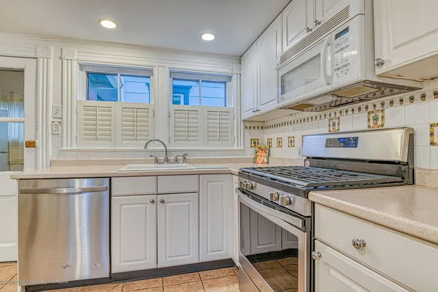 a kitchen with granite countertop a stove sink and cabinets