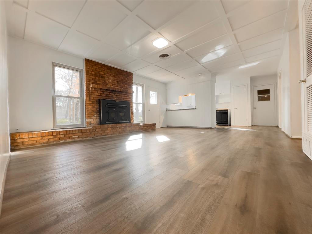 1938 Spring Drive Keller, TX 76262 - Photo 11 of 16 an empty room with wooden floor and fireplace
