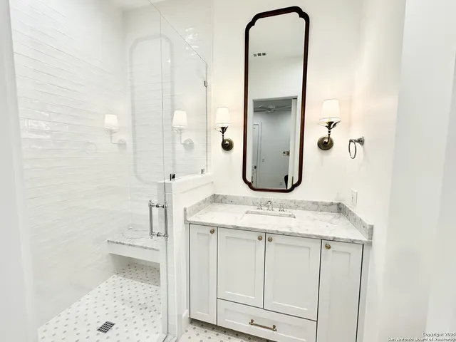 a bathroom with a granite countertop sink a toilet and a mirror