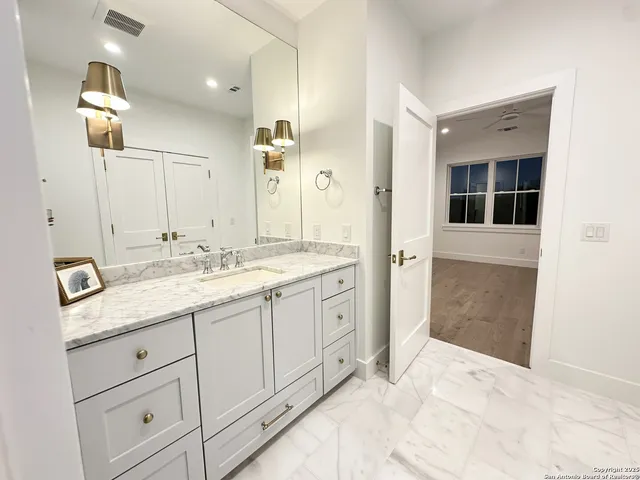 a bathroom with a granite countertop sink mirror and