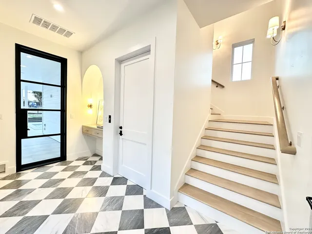 a view of a bedroom with wooden floor and white walls
