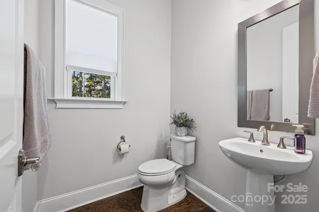 a bathroom with a sink toilet and a mirror