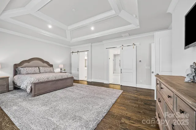 a spacious bedroom with a bed and a flat screen tv