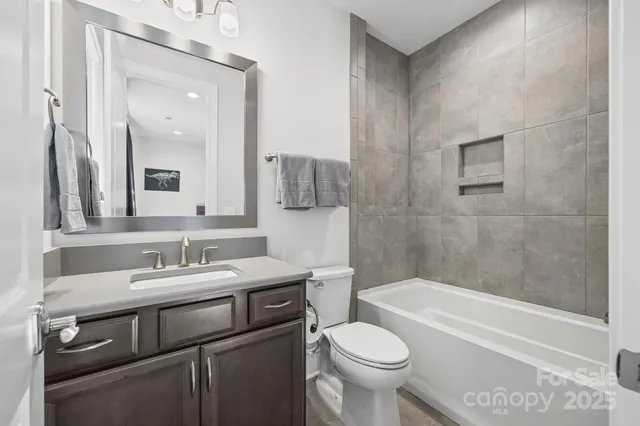 a bathroom with a sink toilet vanity and bathtub