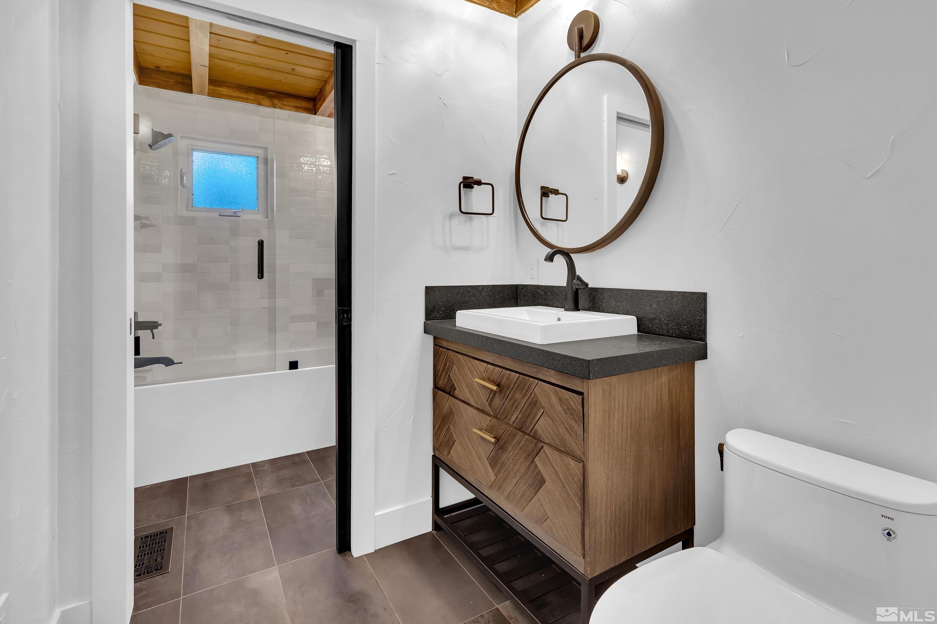 13750 Rancheros Drive Reno, NV 89521 - Photo 24 of 39 a bathroom with a toilet sink vanity and mirror